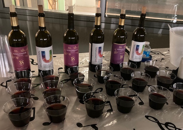 Six bottles of wine and glasses displayed on a table